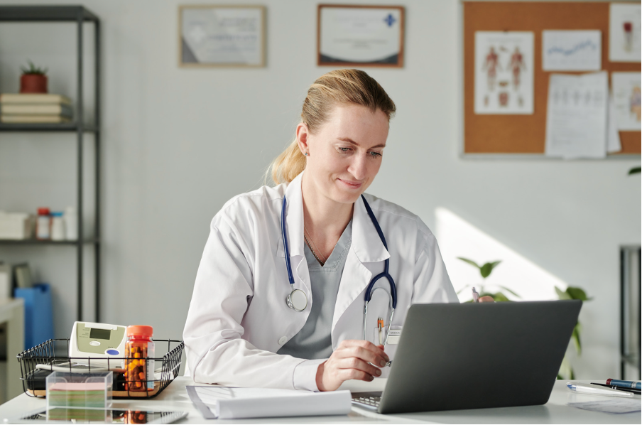 A clinician working at a laptop
